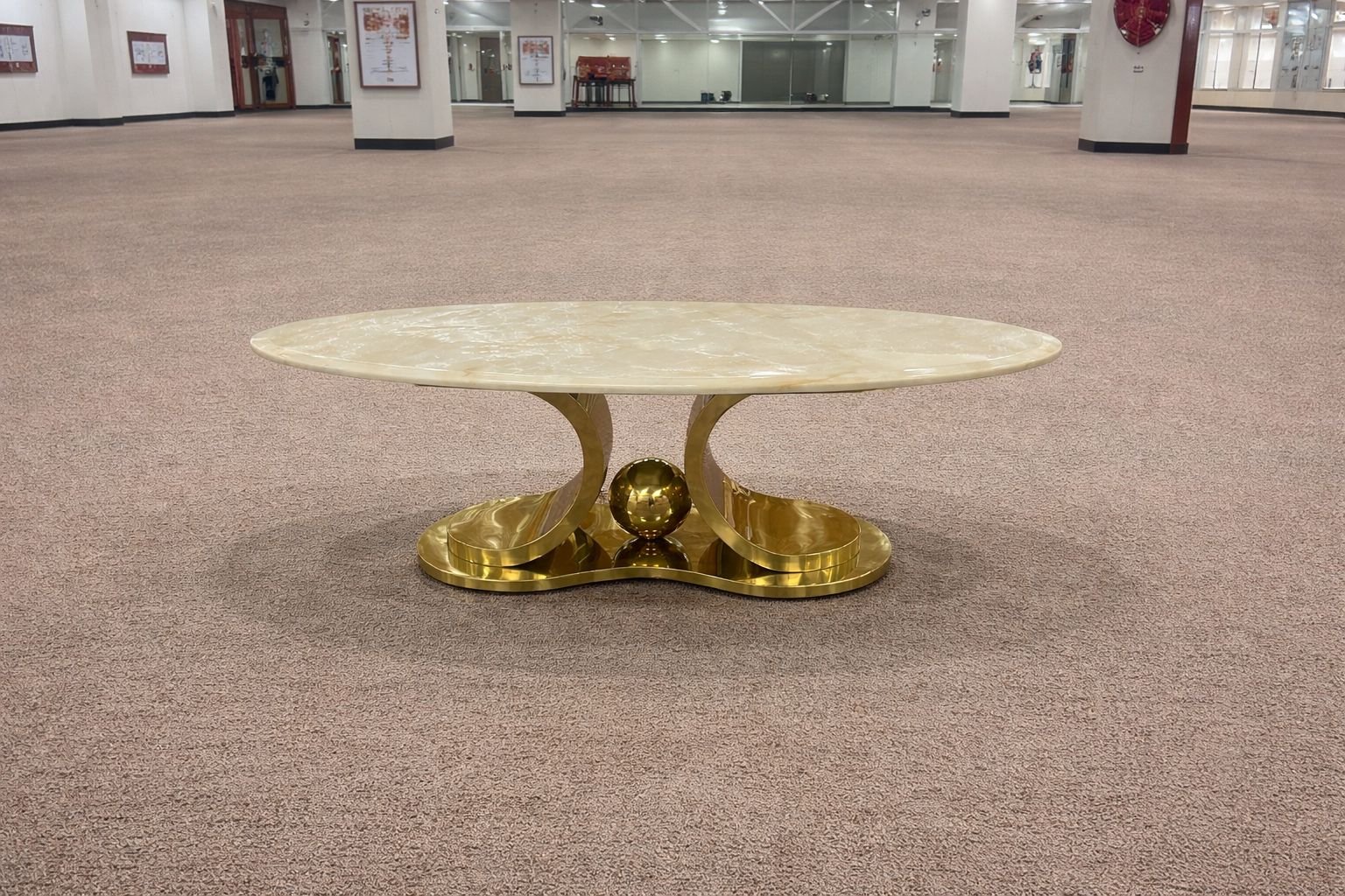 oval coffee table with a marble top and a gold finished metal base