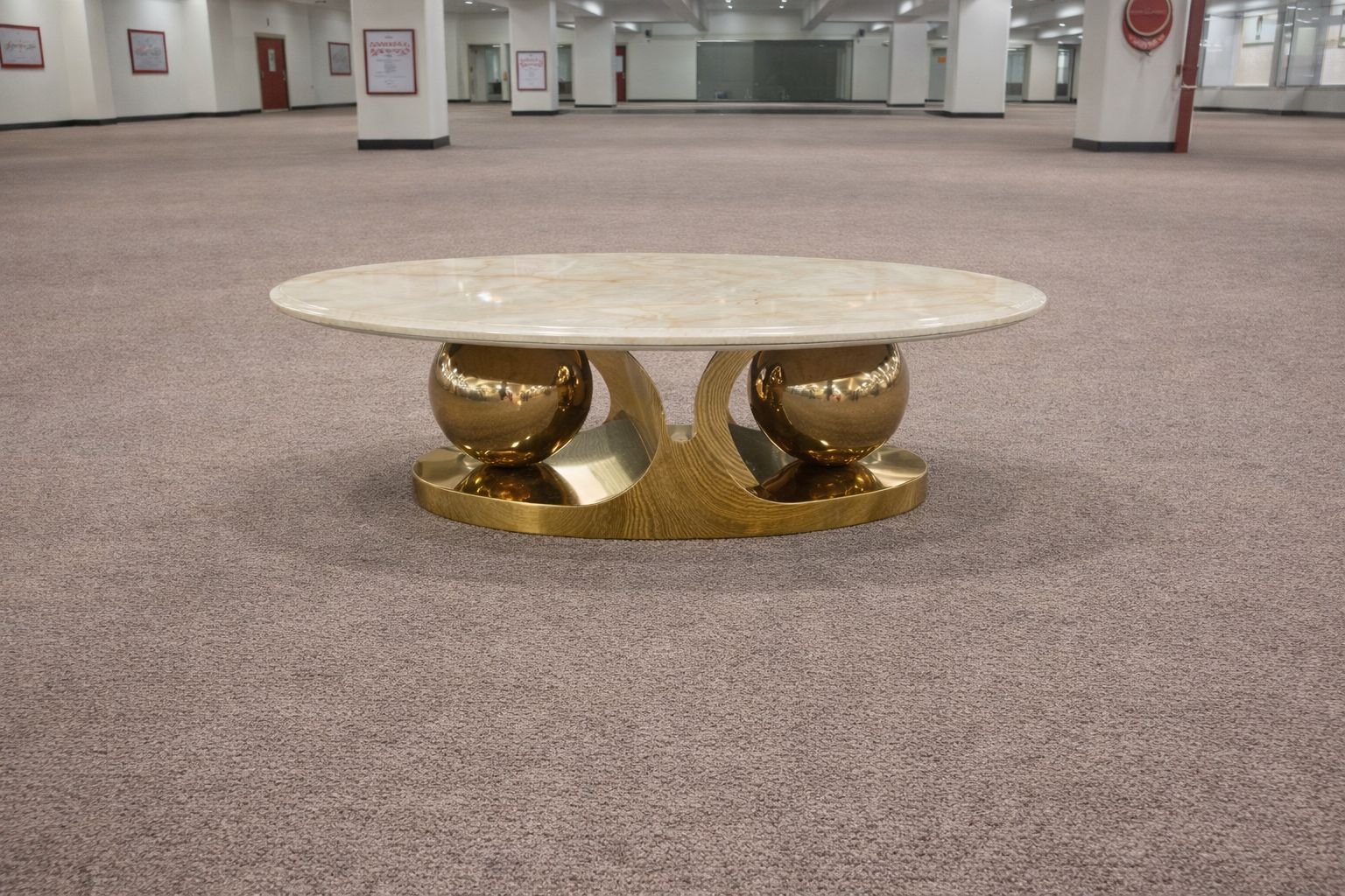 coffee table with an oval marble top and sculptural gold finished metal base.